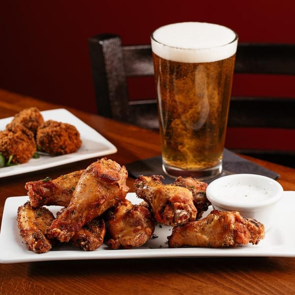 Harold Dean Smoked Goods' smoked chicken wings with dipping sauce and a pint of beer.